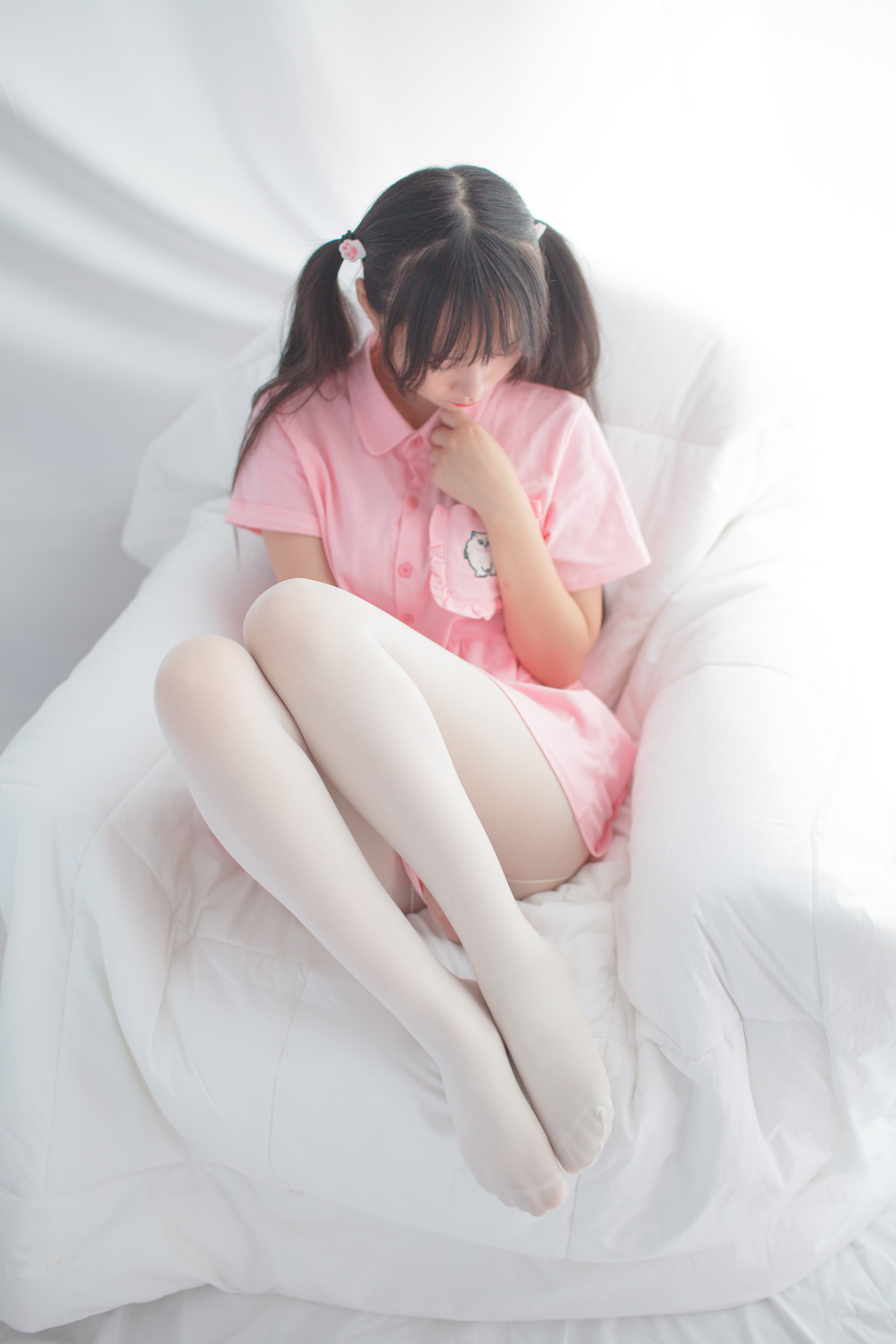 Close-up of toes wiggling from a pink cotton sock beside plush cushions
